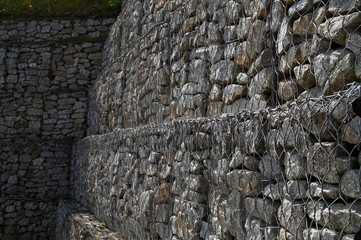 Steel nets filled with granite debris protect the ground from slipping. Gabions.