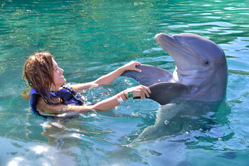 Young girl playing with dolphin in Xel-ha park, Rivera Maya, Mexico - obrazy, fototapety, plakaty