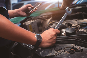 Handyman services  holding a screwdriver and Search for information from mobile phones.