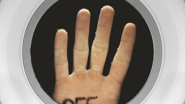 hand with the inscription on the palm: off, appears in the illuminator from the dark depths, close-up