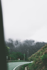 View of sky road over top of mountain with fog and green jungle after raining in morning, Da Lat, Vietnam. The transportation road across mountain.