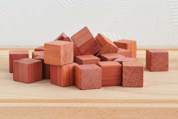 Fragrant wardrobe freshener cubes made of natural pencil cedar wood, close up on wooden background, front view