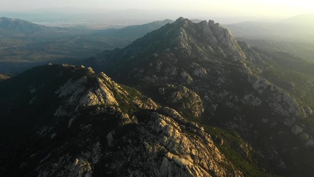 Video from above, aerial view oa a spectacular sunset behind some granite mountains in Sardinia, Italy.