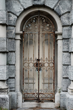 Rusting iron Gated doorway surrounded by granite archway