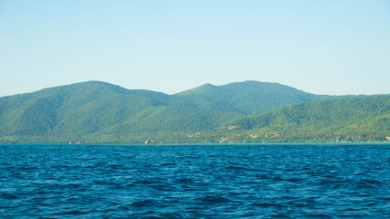 a big green island with deep blue dark sea in karimun jawa island