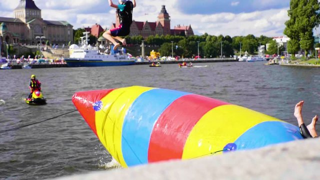 Person launches off a blob into the river, slow motion.