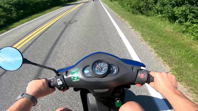 First person view of riding a moped down a rural road