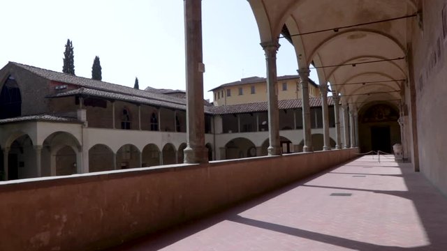 Walking an arcade of the Basilica of the Holy Cross in Florence, Italy