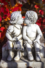 Fototapeta na wymiar Valentine love, kissing statue and red leaves