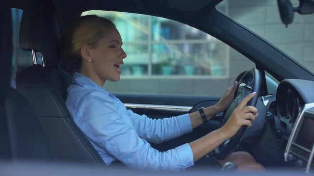 Lady driving car and singing loudly, enjoying successful happy life, positive