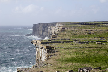 Beautiful view of the cliffs of Inis Mór under blue sky along the Atlantic Ocean from within the...