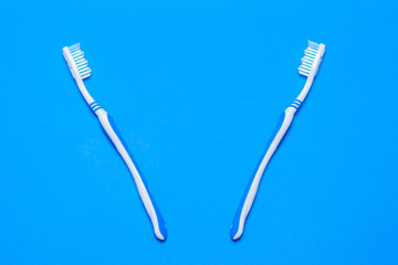 Two toothbrushes on a blue background. The view from the top. Flat lay.