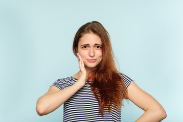 Fototapeta premium facial expression. emotional portrait. dubious dismissive disdainful ironic look. young beautiful girl on blue background.