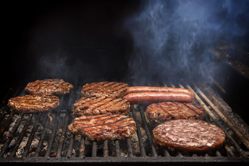 Cooking burgers on hot coals with smoke. Copy space