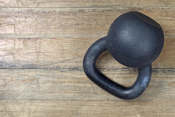 Black heavy kettlebell on on wooden background