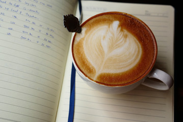lattee coffe on notebook diary background and copyspace, drink and beverage concept.