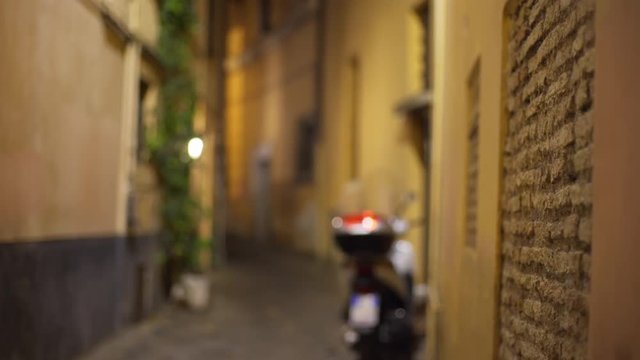 Blurred view of narrow street alley with parked scooter in Europe
