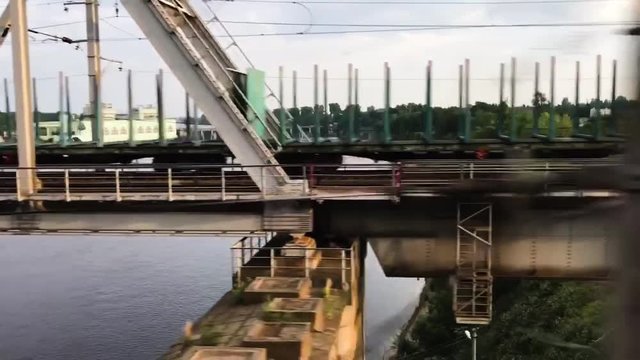 Crossing a bridge with while sitting in the train and seeing cargo train riding to oposite side.
