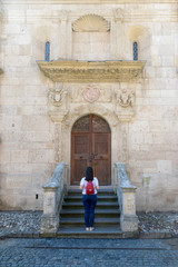 Fototapeta na wymiar Girl standing in front of the Roman-Catholic Cathedral Saint Michael inside the Citadel Alba-Carolina in Alba Iulia, Romania