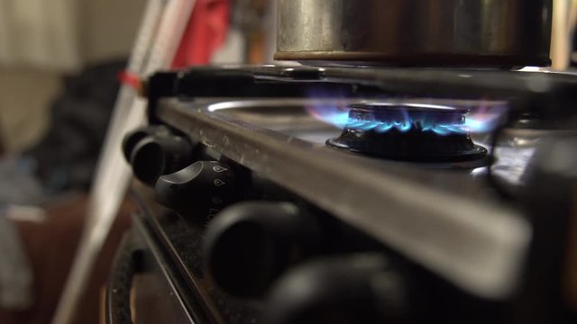 Man sets tea pot onto stainless stove top