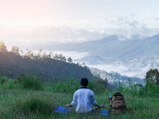 Fototapeta na wymiar male hiker doing yoga on top mountain