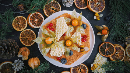 Home made honey cake, Top view on dark background, New Year's decor, Christmas oranges and fir branches