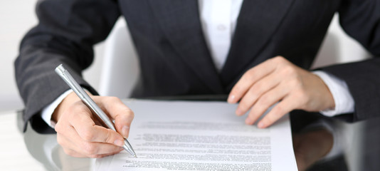 Close-up of female hands with pen over document of contact, business concept