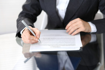 Close-up of female hands with pen over document of contact, business concept