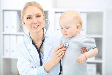 Doctor and patient in hospital. Little girl is being examined by pediatrician with stethoscope. Medicine and health care