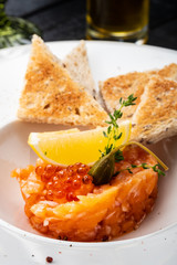 Salmon tartare with capers, lemon and red caviar.