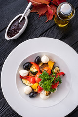 Salad with cherry tomatoes, sweet peppers, olives, zucchini and cheese.