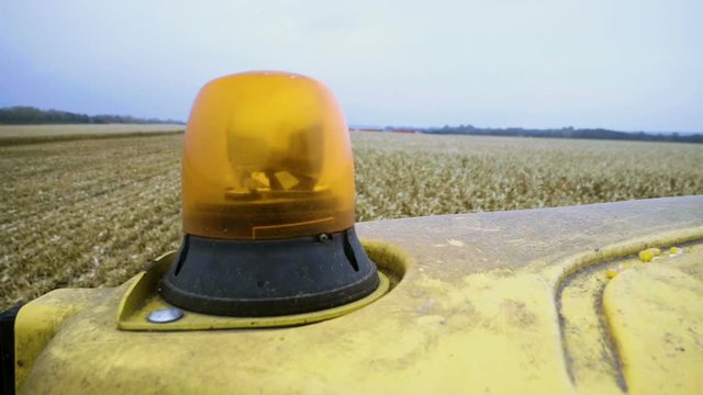 Flashing lights on the storage bin of the combine harvesting corn. Slow motion. HD