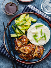 Hoisin Chicken. Traditional Asian cuisine. Chicken with sauce, rice and pickled cucumbers.