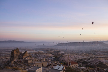Unreal world of Cappadocia. Colorful sunrise in Red Rose valley in April. Cavusin village located, Nevsehir Province in the Cappadocia region of Turkey, Asia. Traveling concept background
