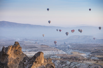 Unreal world of Cappadocia. Colorful sunrise in Red Rose valley in April. Cavusin village located, Nevsehir Province in the Cappadocia region of Turkey, Asia. Traveling concept background