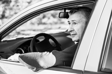 Portrait Of A Happy Mature man Driving Car To Go To Work or travels. Concept of automobile and popular hobby  