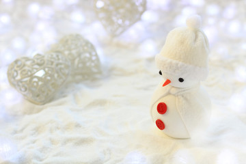 Merry Christmas & Happy New Year greeting card with copy space. Little snowman in the white glitter...