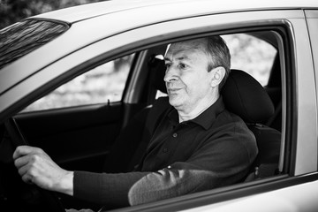 Portrait of stressed mature man in car drivers seat. Crisis of middle age and man's life after 50 years. Senior serious or sad or depressed man sitting in his car, toned 