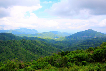 View of the lush green mountains and valley with floating clouds in the backdrop a scenic view from, Pha Sorn Kaew, in Khao Kor, Phetchabun, Thailand.