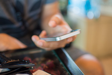 man holding smart phone for use internet with vintage tone. subject is blurred.