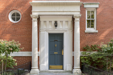 Decorated main door, columns and brick wall in New York