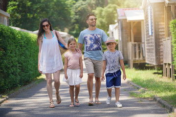 Family walking in camp village during holidays - obrazy, fototapety, plakaty