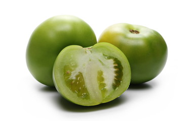 Fresh green tomato sliced in half, isolated on white background