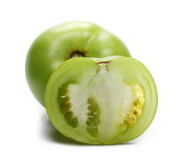 Fresh green tomato sliced in half, isolated on white background