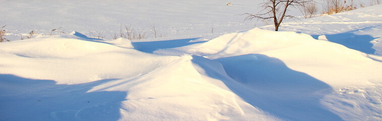 Winter, snow - beautiful landcsape snowdrifts on the endless field, north day panorama view