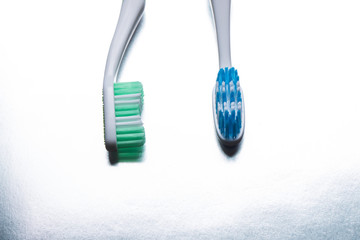 Blue and green toothbrush on a shiny gray background