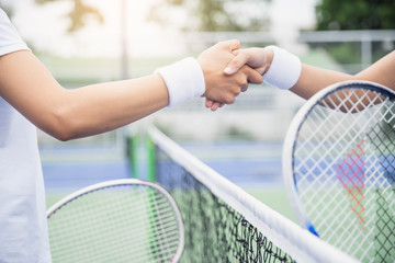 Women tennis player handshaking after playing a tennis match. Handshake at tennis court -...