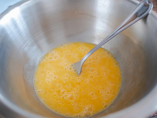 Top view of eggs yolks on metallic bowl. Spanish omelet recipe