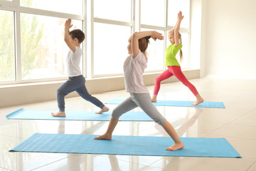 Naklejka premium Little children practicing yoga indoors