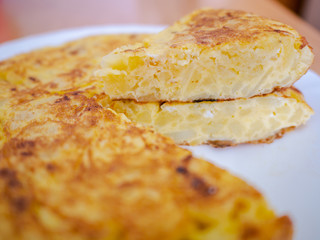 Close up of spanish omelet on white plate on wooden table. Spanish omelette recipe
